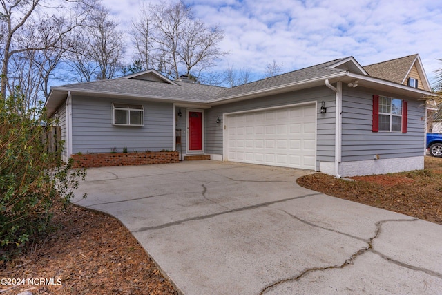 single story home featuring a garage, concrete driveway, and a shingled roof