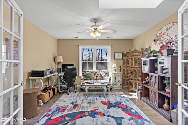 office area with a ceiling fan, french doors, visible vents, and wood finished floors