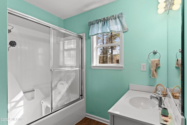 bathroom featuring toilet, baseboards, wood finished floors, and vanity