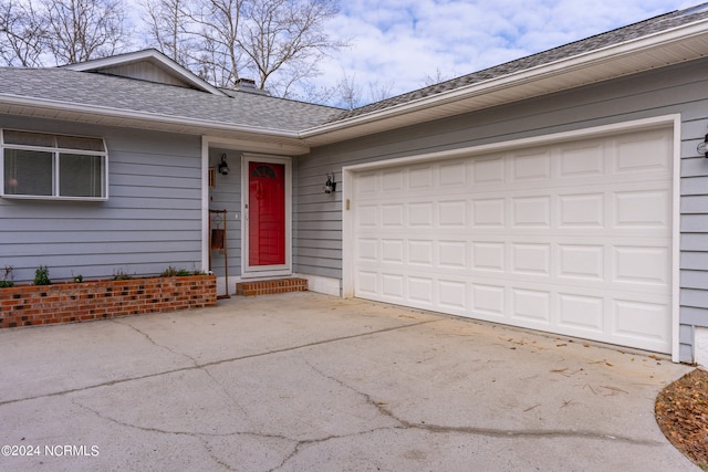 view of front of house featuring concrete driveway, roof with shingles, and an attached garage