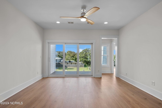 empty room featuring visible vents, baseboards, and wood finished floors