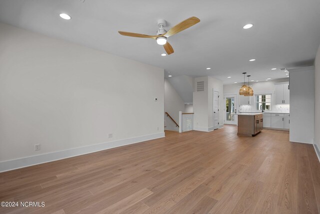 unfurnished living room with light hardwood / wood-style flooring and ceiling fan