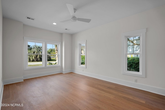 empty room featuring recessed lighting, wood finished floors, visible vents, and baseboards