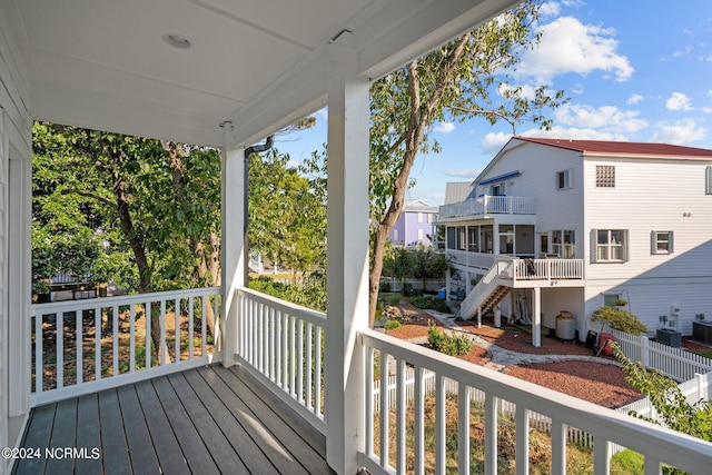 wooden terrace with covered porch, a residential view, and central air condition unit