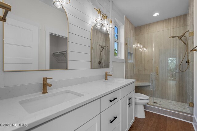 bathroom featuring walk in shower, hardwood / wood-style flooring, vanity, and toilet