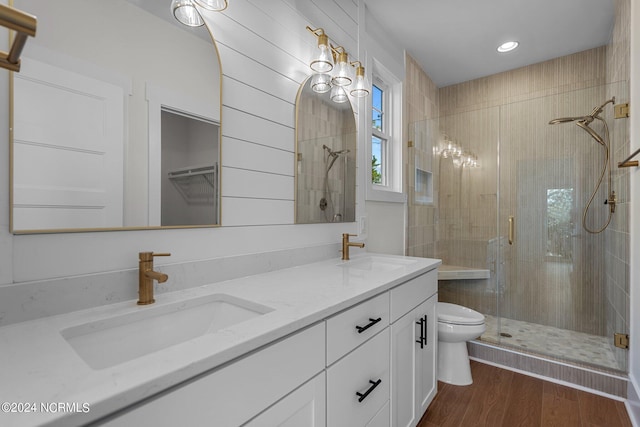 bathroom featuring a stall shower, a sink, and wood finished floors