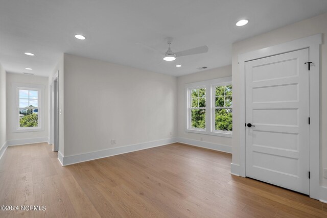 spare room featuring light hardwood / wood-style flooring, a wealth of natural light, and ceiling fan