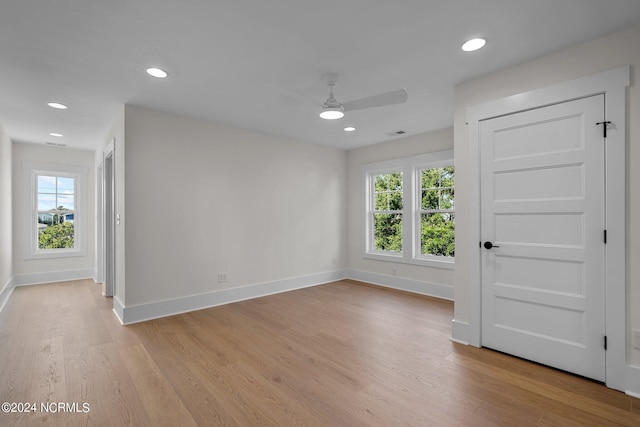 empty room featuring a healthy amount of sunlight, light wood finished floors, and baseboards