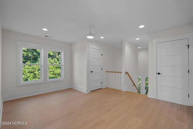 empty room with light wood-type flooring and ceiling fan