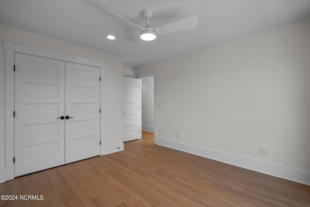 unfurnished bedroom with ceiling fan, a closet, light wood-type flooring, and baseboards