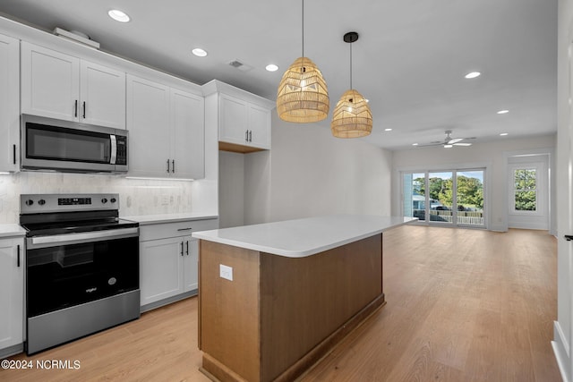 kitchen featuring white cabinets, light countertops, appliances with stainless steel finishes, light wood-type flooring, and tasteful backsplash