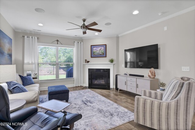 living room with ceiling fan, ornamental molding, and hardwood / wood-style floors