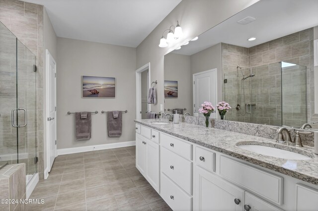 bathroom with tile patterned flooring, an enclosed shower, and vanity