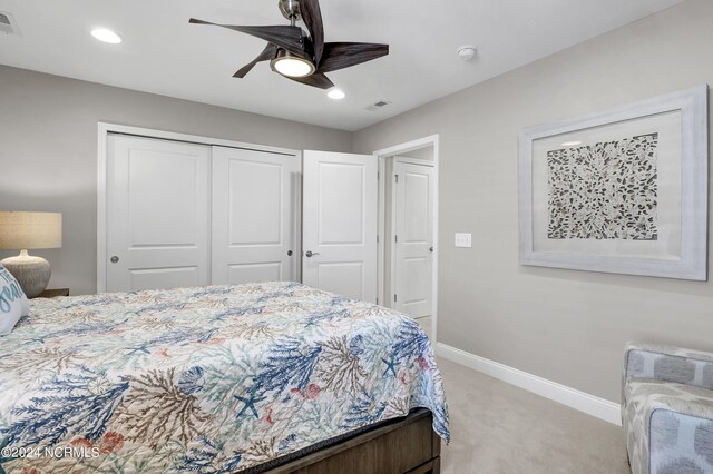 carpeted bedroom with ceiling fan and a closet