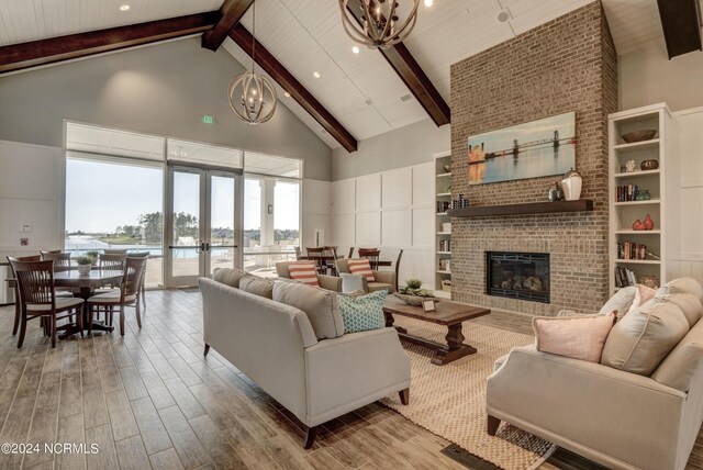 living room with high vaulted ceiling, a chandelier, and light hardwood / wood-style floors