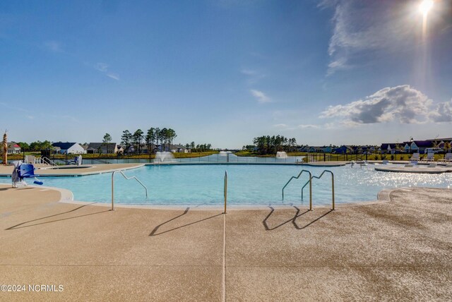 view of swimming pool with pool water feature and a patio area