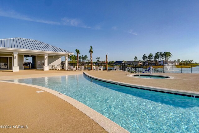 view of swimming pool featuring a community hot tub and a patio