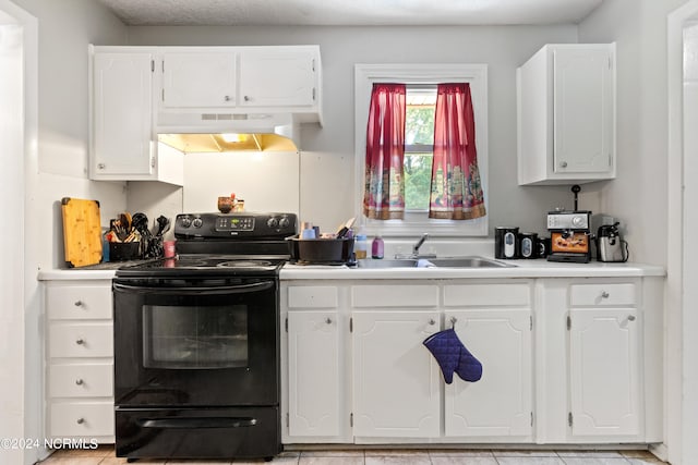 kitchen featuring black electric range, sink, white cabinets, and light tile patterned flooring