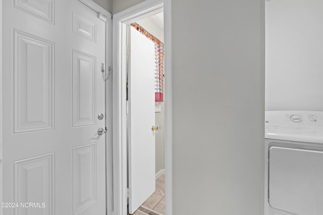 clothes washing area featuring washer / dryer and light tile patterned flooring