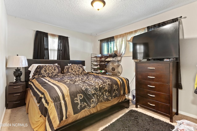 bedroom featuring light colored carpet and a textured ceiling