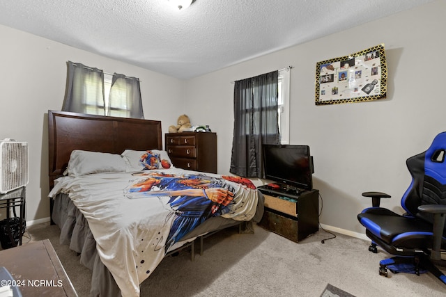 carpeted bedroom featuring a textured ceiling and baseboards