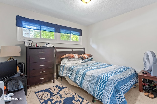 bedroom featuring light colored carpet and a textured ceiling