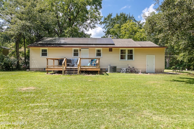 back of property with a wooden deck, a lawn, and central AC unit