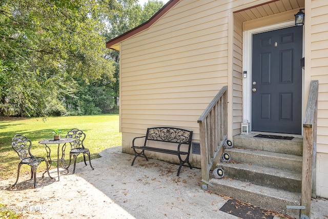 entrance to property with a lawn