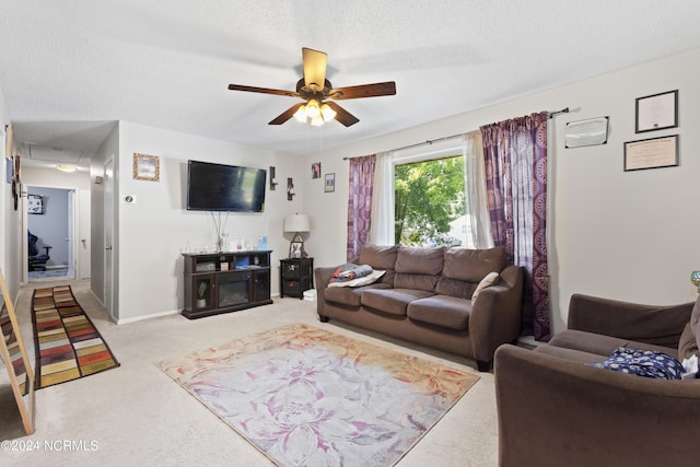 living room featuring light carpet, baseboards, a ceiling fan, and a textured ceiling