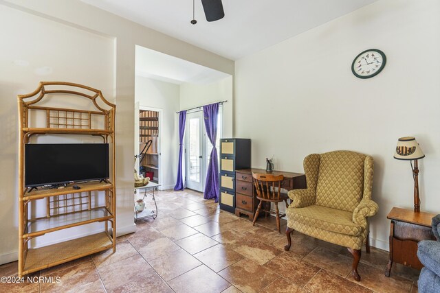 interior space with a ceiling fan and baseboards