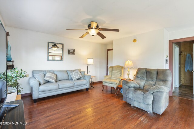 living room featuring ceiling fan and dark wood-type flooring