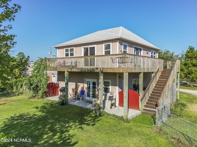 rear view of house with stairway, a yard, a deck, french doors, and a patio area