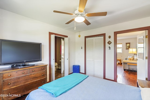 bedroom with baseboards, connected bathroom, ceiling fan, wood finished floors, and a closet