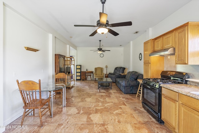 kitchen with visible vents, black gas range oven, stone finish floor, open floor plan, and under cabinet range hood