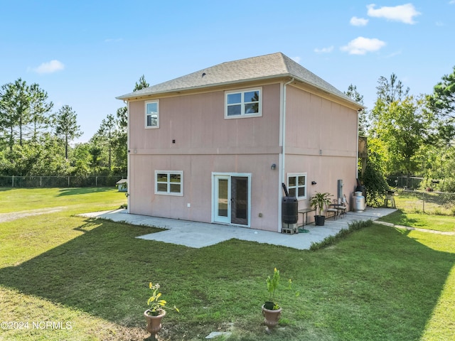 back of house with central air condition unit, a yard, and a patio