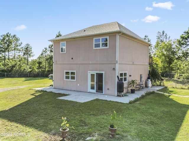 back of property with central air condition unit, fence, a patio, and a yard