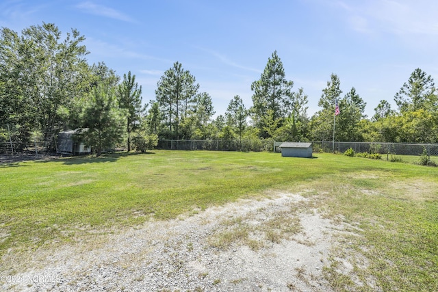 view of yard with a storage shed, fence, and an outdoor structure