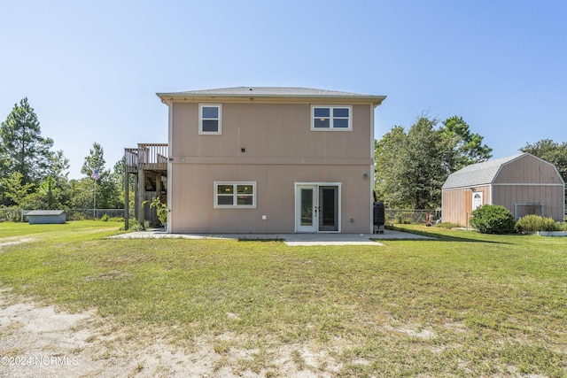 rear view of property with a yard, french doors, and an outdoor structure