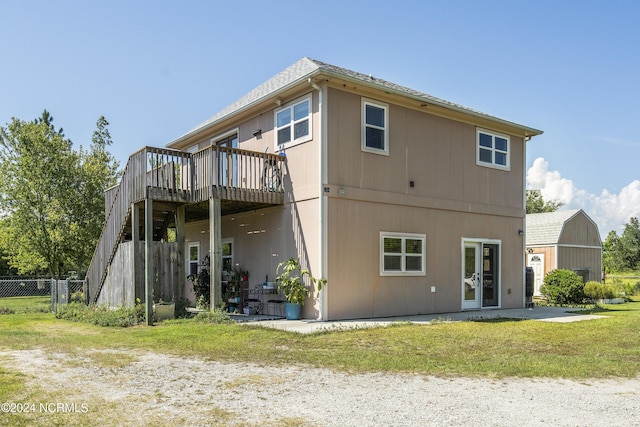 rear view of house featuring french doors, a yard, stairway, fence, and a wooden deck