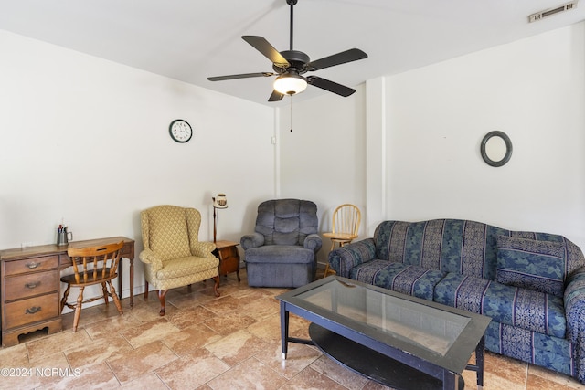 living room featuring ceiling fan, stone finish floor, and visible vents