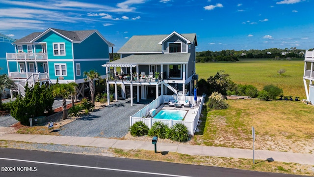 back of house with a balcony, a patio, a fenced in pool, and a yard