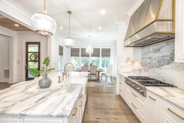6404 Westport Dr, Wilmington, NC 28409 - kitchen with range hood, stainless steel gas cooktop, a chandelier, plenty of natural light, and recessed lighting