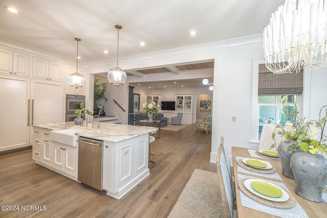 6404 Westport Dr, Wilmington, NC 28409 - kitchen with appliances with stainless steel finishes, a chandelier, white cabinetry, wood finished floors, and light stone countertops