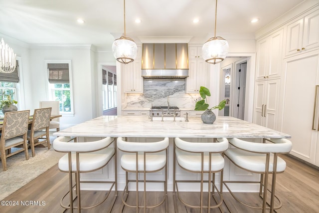 6404 Westport Dr, Wilmington, NC 28409 - kitchen with wall chimney exhaust hood, wood finished floors, light stone countertops, tasteful backsplash, and crown molding