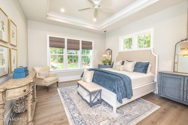 6404 Westport Dr, Wilmington, NC 28409 - bedroom featuring a raised ceiling, light wood-style flooring, crown molding, and ceiling fan