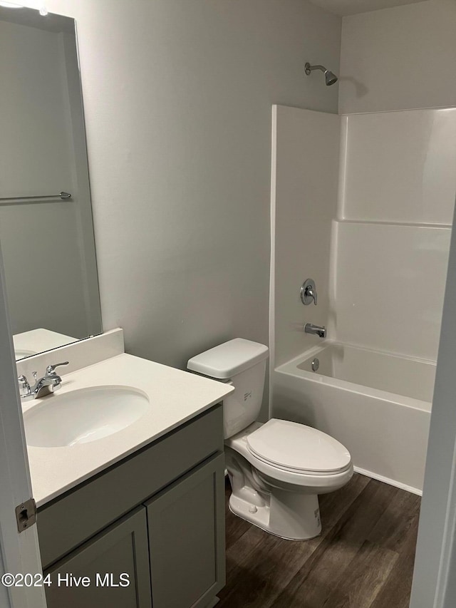 full bathroom featuring bathtub / shower combination, wood-type flooring, vanity, and toilet