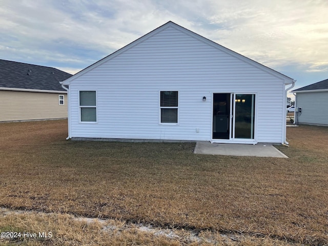 rear view of house with a patio area and a lawn