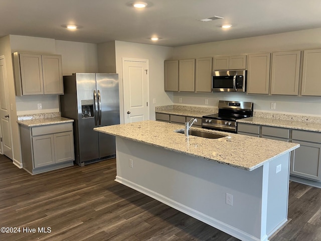 kitchen with gray cabinetry, dark wood-type flooring, a center island with sink, sink, and stainless steel appliances