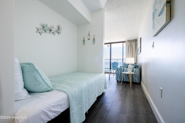 bedroom with baseboards, a textured ceiling, floor to ceiling windows, and dark wood-type flooring