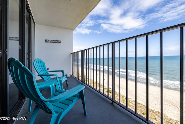 balcony featuring a water view and a beach view